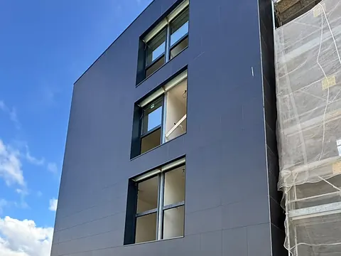 Fachada negra de obra nueva con ventanas